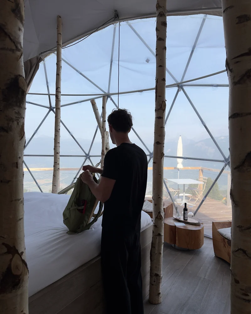 Sion inside a WhitePod dome in the Swiss Alps, looking out over the valley
